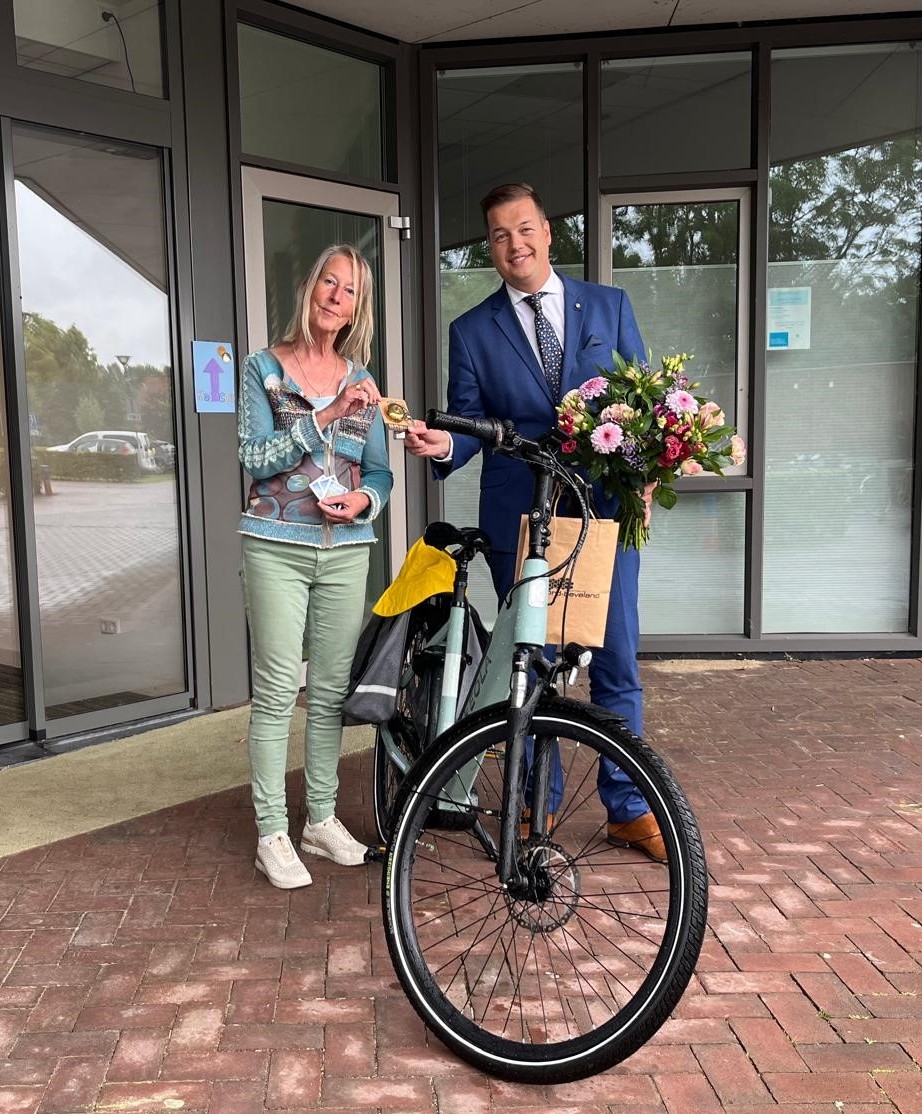 Wethouder van Belzen overhandigt de 'Gouden Fietsbel' aan de winnares